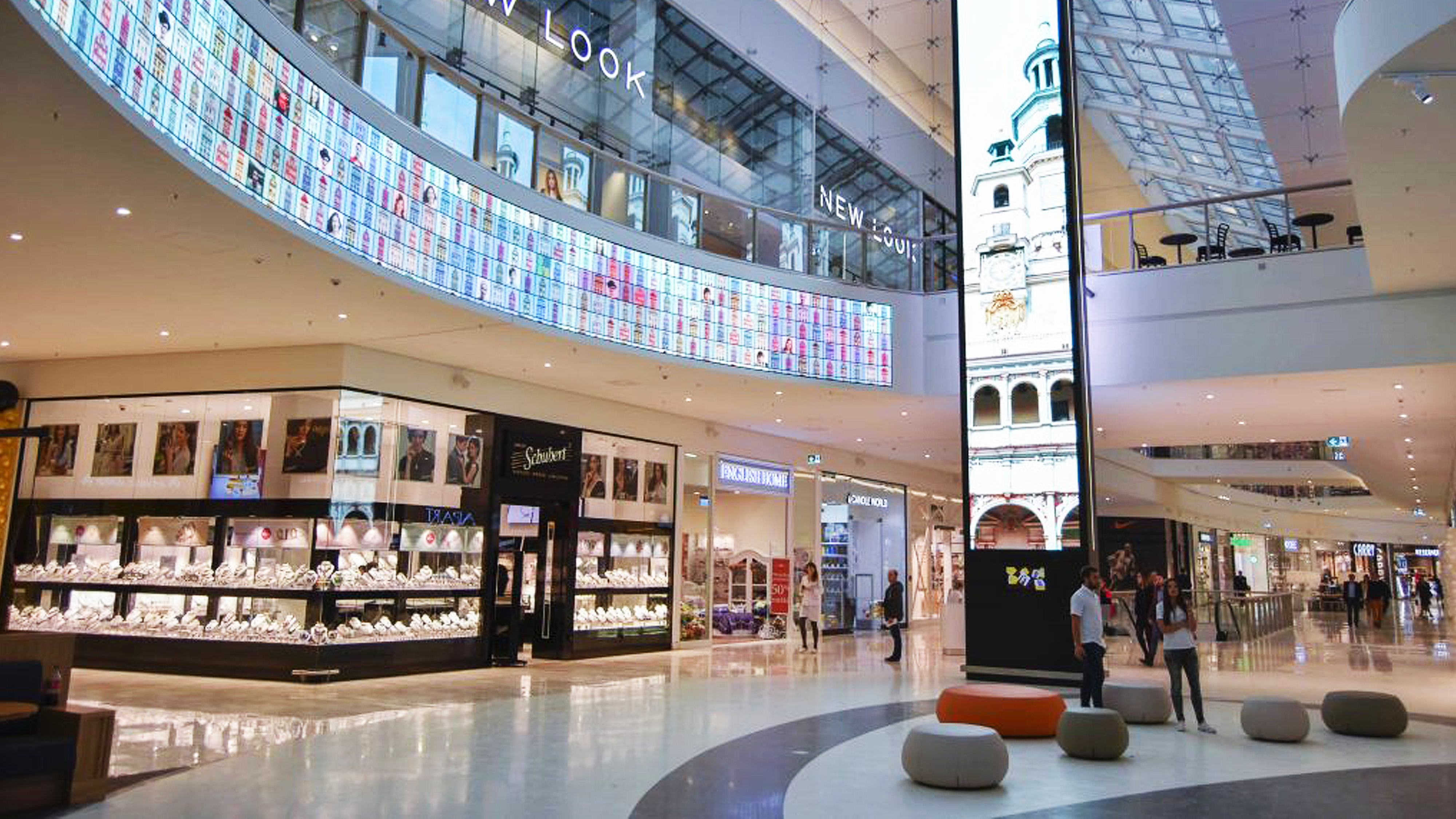 Shopping mall with a lot of stores and bright digital screens
